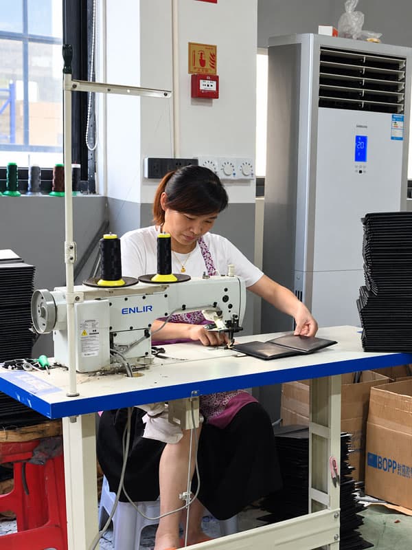 Skilled worker sewing menu covers in Menunique in-house operation